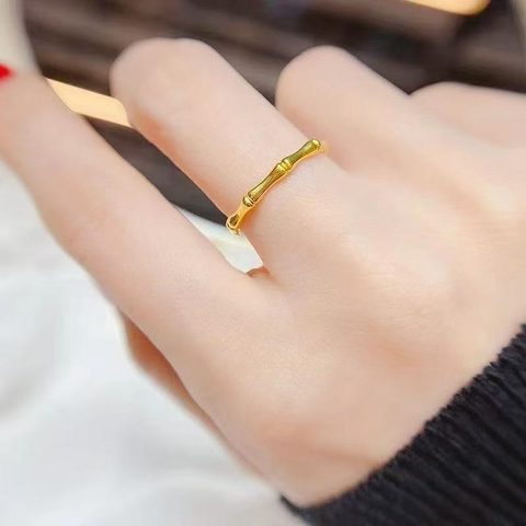 Thin gold bamboo-joint ring on a finger