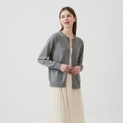 Grey thin round-neck cardigan over a cream skirt