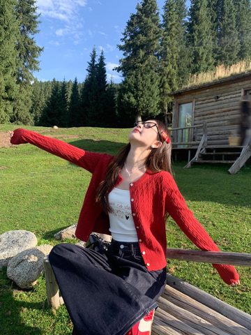 Red cable-knit cardigan worn outdoors